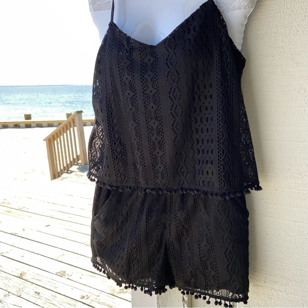 American Rag  Co black lace romper with adjustable straps. Pockets and pom-poms.